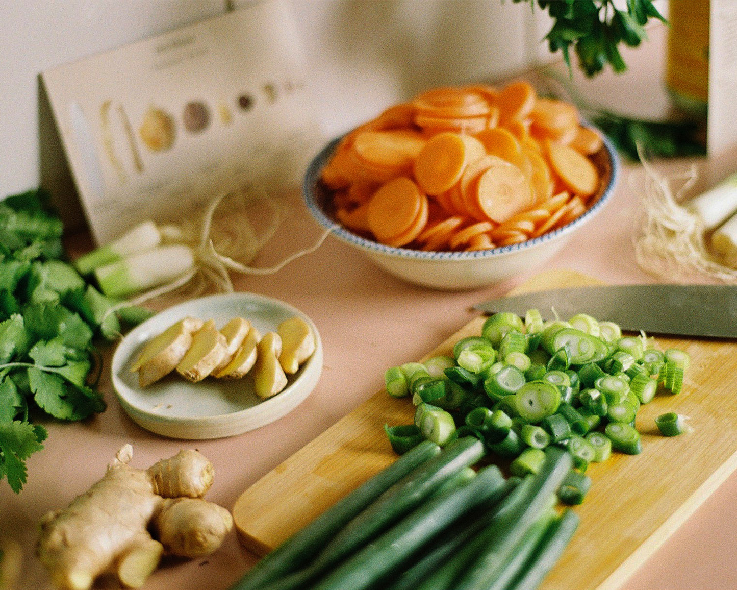 Kitchen bench preparing herbal soup with ginger, spring onion, carrots, ginger and cooking instructions. Image 3