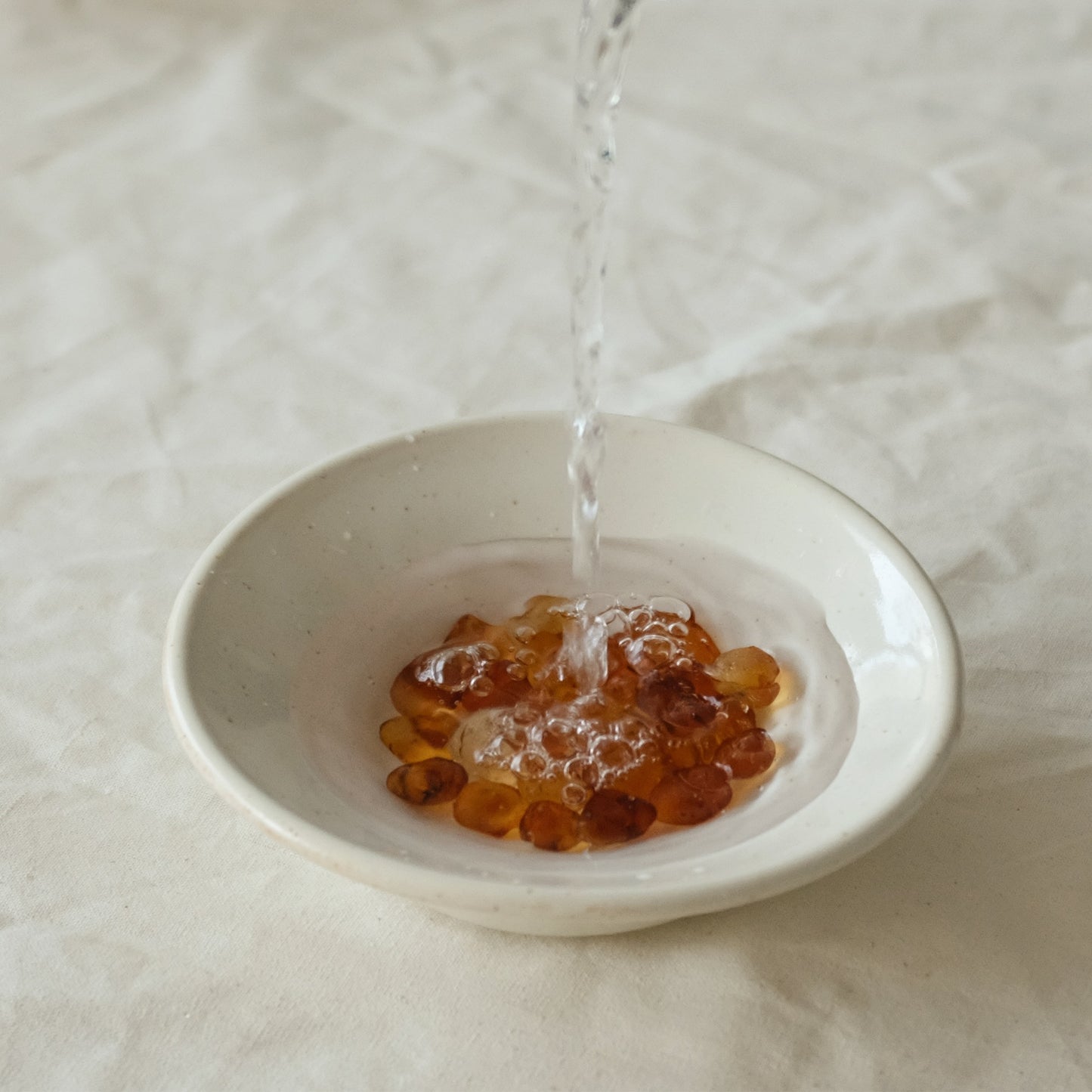 water poured over peach gum in bowl