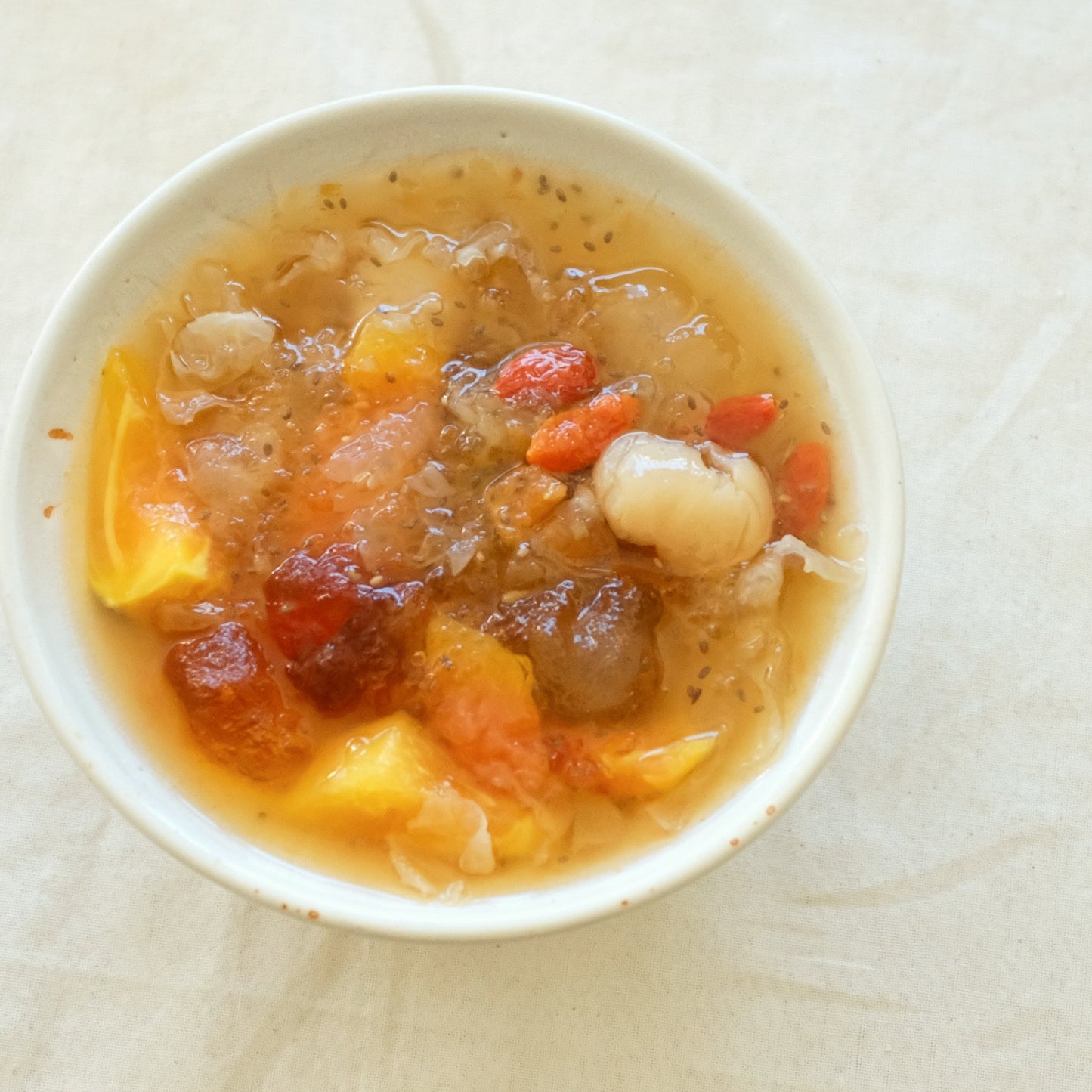 bowl of asian herbal dessert with peach gum, papaya, longan, goji berries, chia seeds.