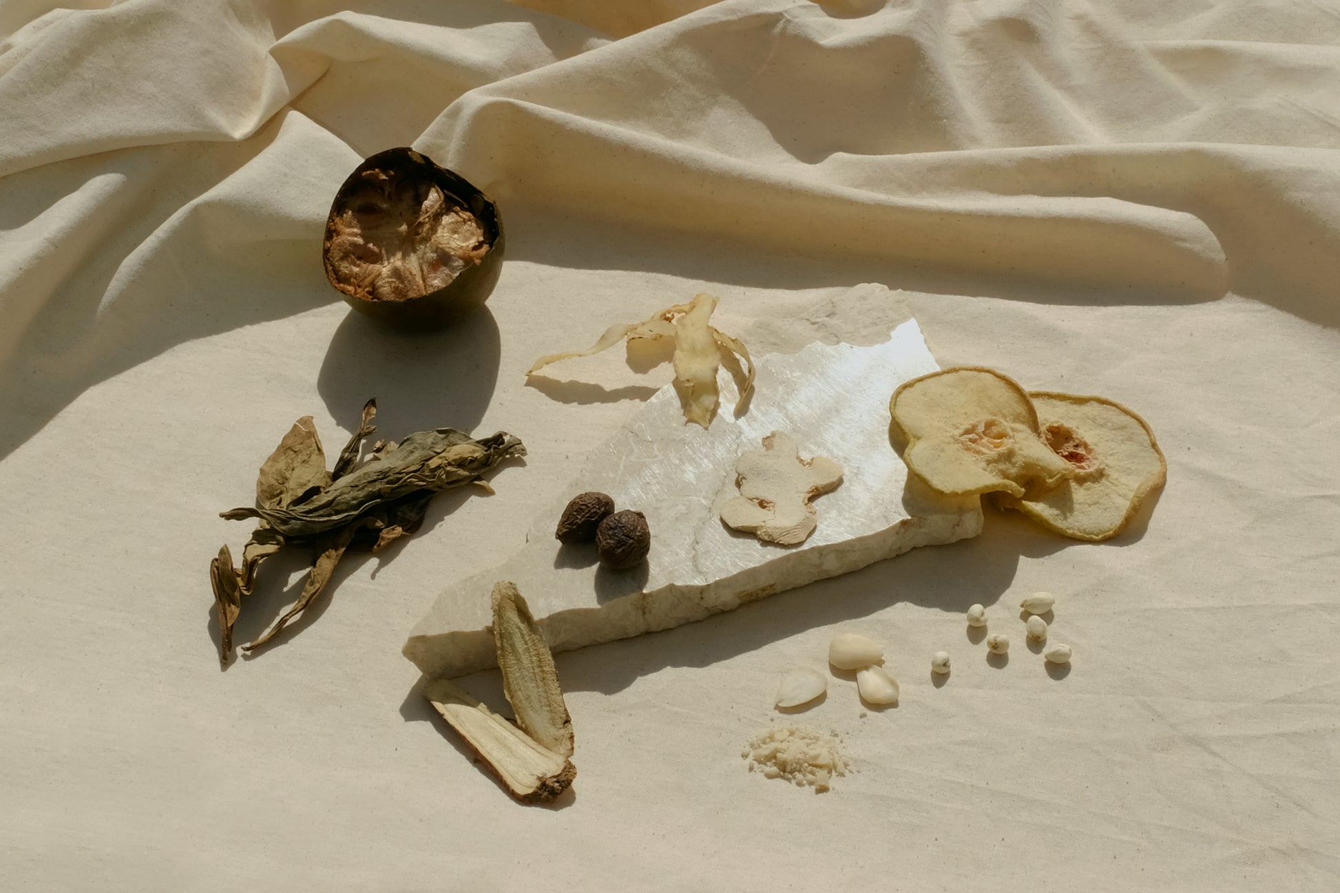  Chinese herbal soup mix on a marble plate with Chinese herbs monk fruit luo Han Guo, dried pear, chuan bei, dragon tongue leaf, sweet apricot kernel, bitter apricot kernel, liquorice root, Solomon's seal yu zhu, dried ginger, malva nut pang dang hai. Image 2