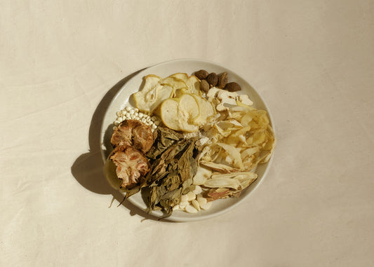 Chinese herbal soup mix on a plate with Chinese herbs monk fruit luo Han Guo, dried pear, chuan bei, dragon tongue leaf, sweet apricot kernel, bitter apricot kernel, liquorice root, Solomon's seal yu zhu, dried ginger, malva nut pang dang hai . Image 1